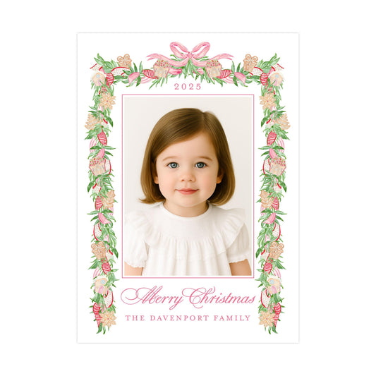 A young girl with brown hair and blue eyes is smiling at the camera, framed by a decorative border with pink and green floral elements. The text "Merry Christmas" and "The Davenport Family" is displayed below the photo.
