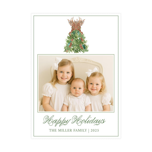 A family portrait of three young girls in white dresses, with a Christmas tree and reindeer decoration in the background. The text below the image reads "Happy Holidays The Miller Family 2025".