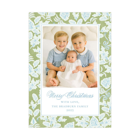 A family portrait of two young boys and a baby, with a floral pattern surrounding the photo.