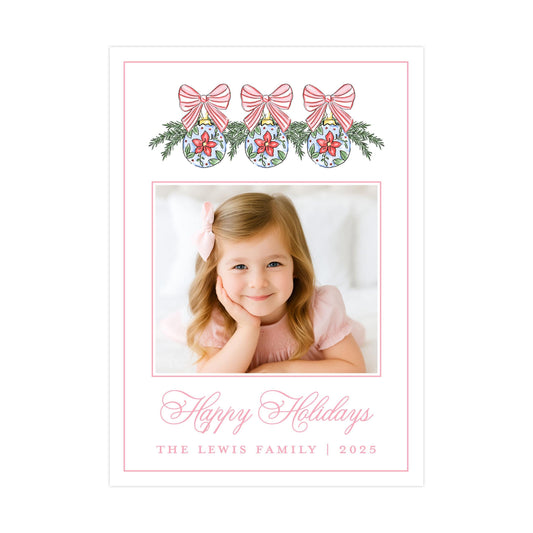 A young girl with a bow in her hair is smiling at the camera, surrounded by festive holiday decorations and a message wishing the recipient a happy holiday season.