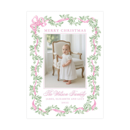 A framed photograph of a baby girl in a white dress, standing in a chair with a floral border around the edges. The text "Merry Christmas" is displayed above the photo, and "The Wilson Family" is written below it.