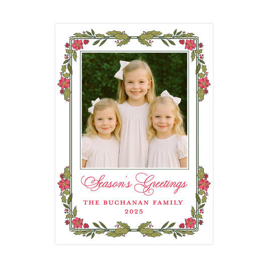 A family portrait of three young girls in white dresses, with a floral border around the edges. The text below the photo reads "Season's Greetings The Buchanan Family 2025".