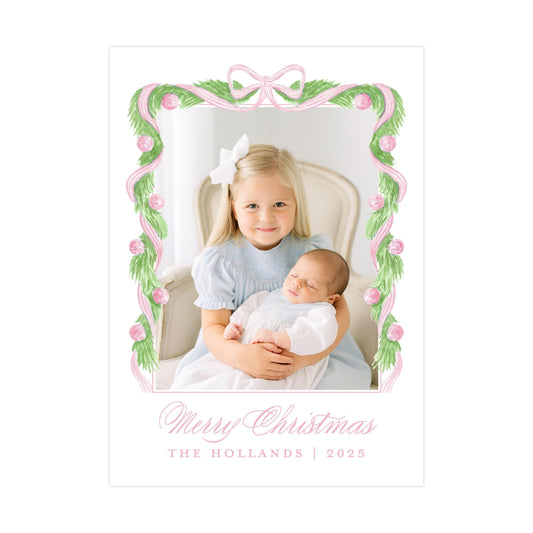 A young girl in a blue dress is holding a sleeping baby in her arms, with a decorative frame around them. The text at the bottom of the image reads "Merry Christmas THE HOLLANS | 2025".