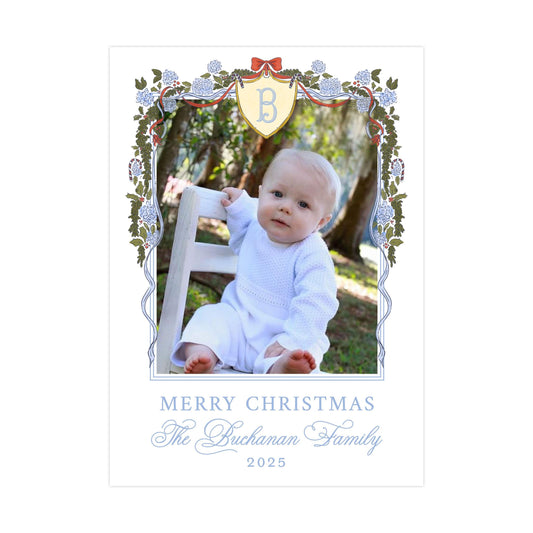 A baby sitting in a chair, surrounded by a decorative border with floral elements and a monogrammed letter "B" in the center. The text below the image reads "MERRY CHRISTMAS The Buchan Family 2015".