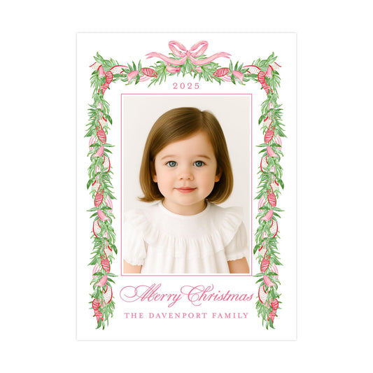 A young girl with brown hair and blue eyes is smiling at the camera, framed within a decorative border of pink and green leaves and flowers. The text "Merry Christmas" and "The Davenport Family" is displayed below the photo.