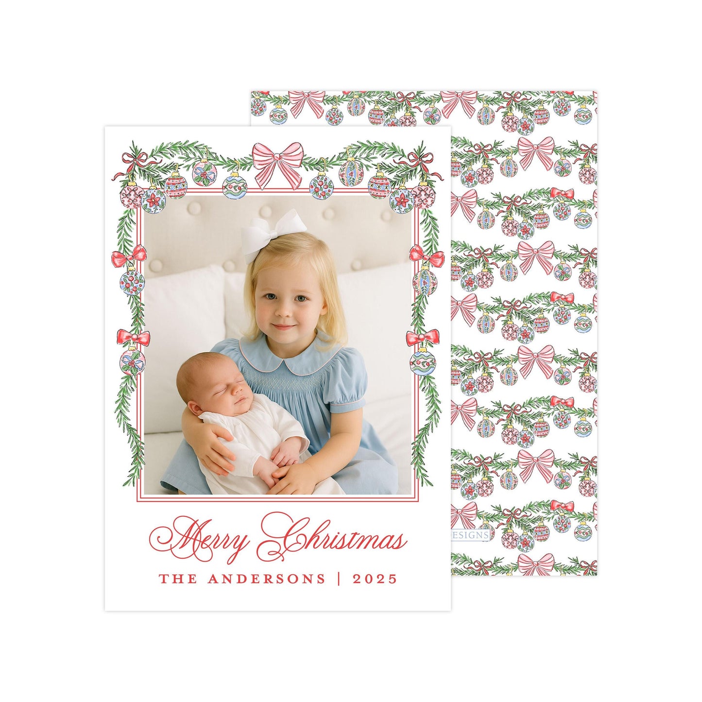 A young girl in a blue dress is holding a sleeping baby in her arms, with a festive Christmas-themed background featuring red and green decorations.