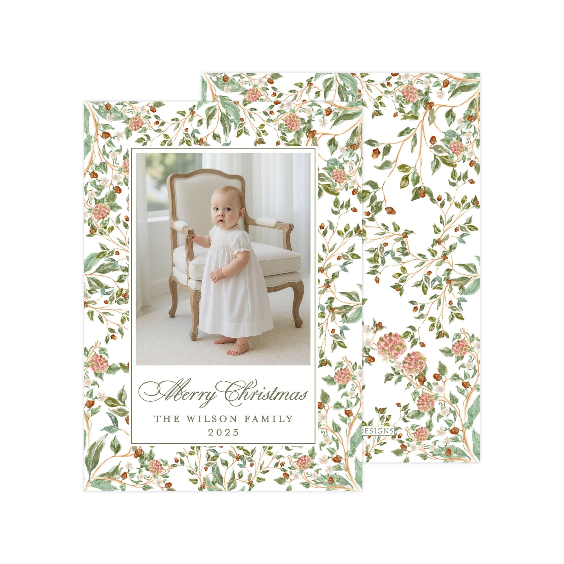A baby dressed in a white dress is standing in a chair, with a floral pattern surrounding the image. The text at the bottom of the image reads "Merry Christmas THE WILSON FAMILY 2015".