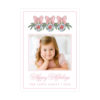 A young girl with a bow in her hair is smiling at the camera, surrounded by festive holiday decorations and a message wishing the recipient a happy holiday season.