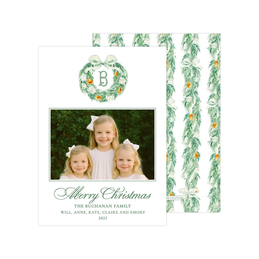 A Christmas card featuring three young girls with bows, surrounded by a wreath and greenery. The card has a personalized message and a monogrammed letter "B" in the center.
