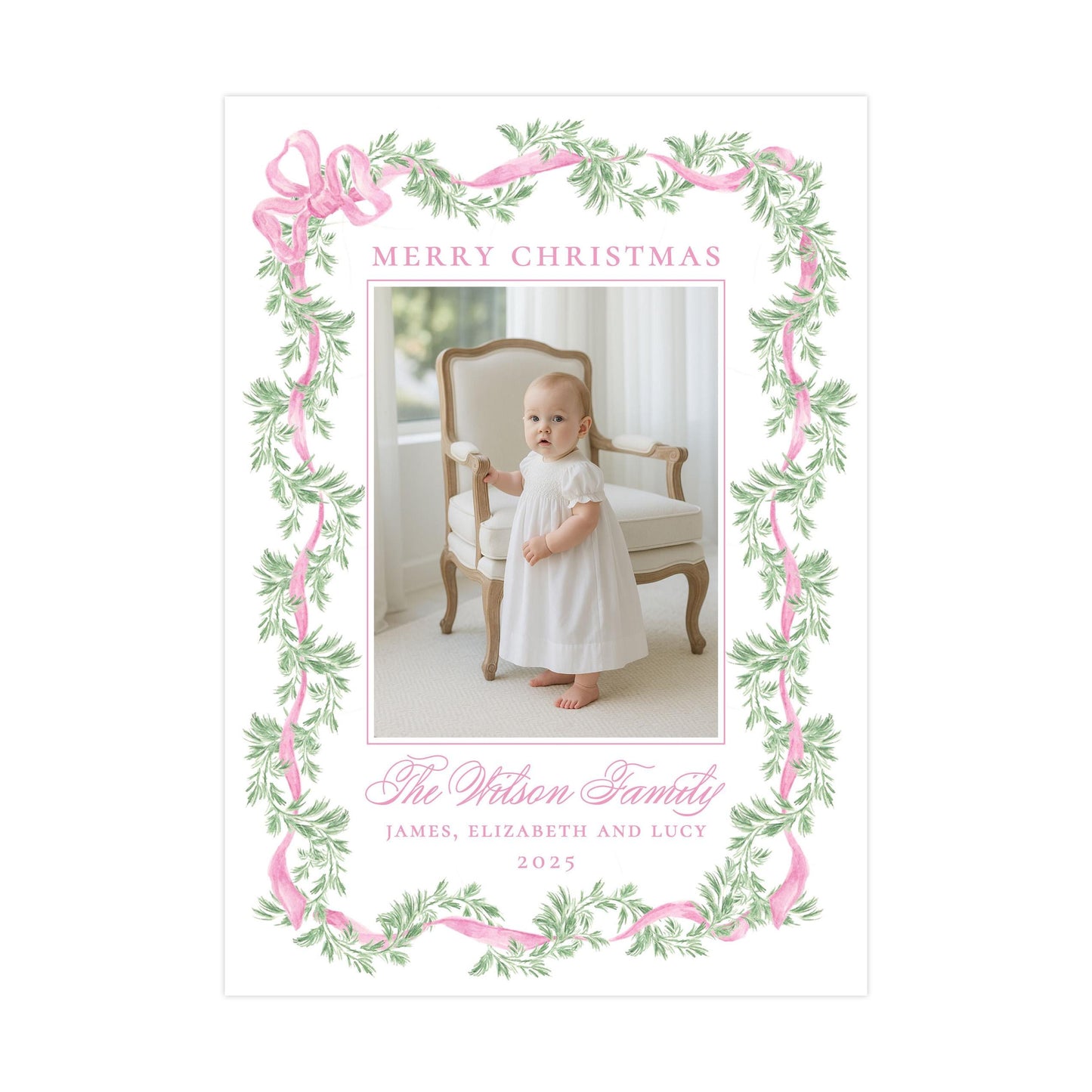 A framed photograph of a baby girl in a white dress, standing in a chair with a floral border around the edges. The text &quot;Merry Christmas&quot; is displayed above the photo, and &quot;The Wilson Family&quot; is written below it.
