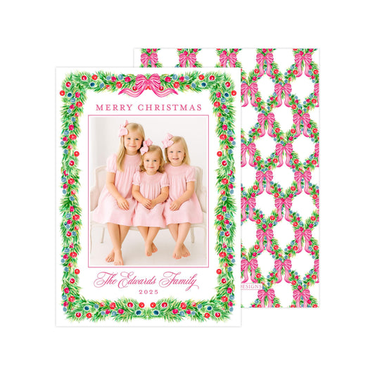A Christmas card featuring three young girls in pink dresses, with a festive wreath border and the text "Merry Christmas" and "The Edwards Family, 2020" printed on it.