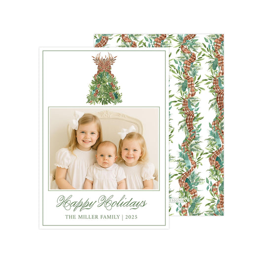 A holiday card featuring three young girls in white dresses, with a Christmas tree and ribbon design in the background.