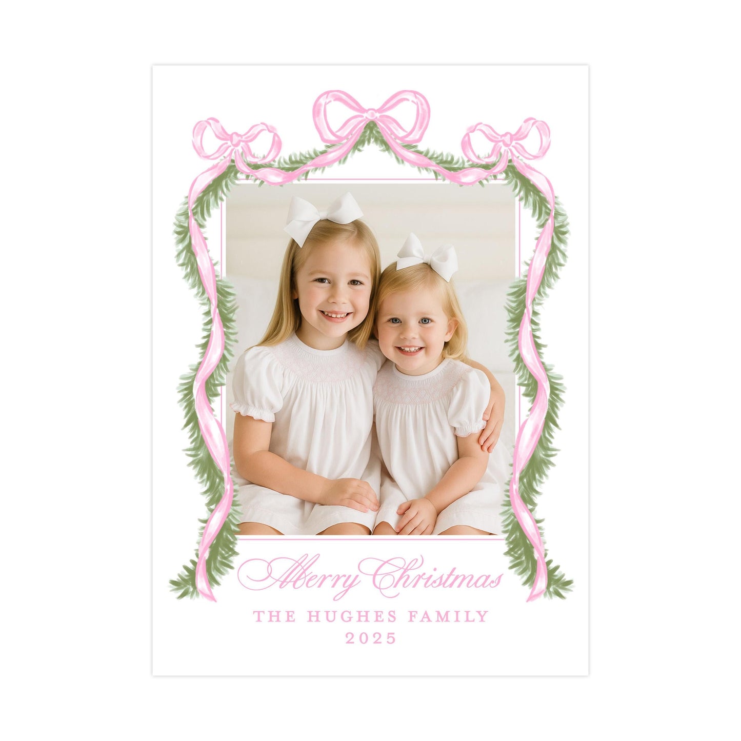 A photo of two young girls smiling and sitting together, framed by a pink ribbon and greenery, with the text &quot;Merry Christmas&quot; and &quot;The Hughes Family&quot; below.
