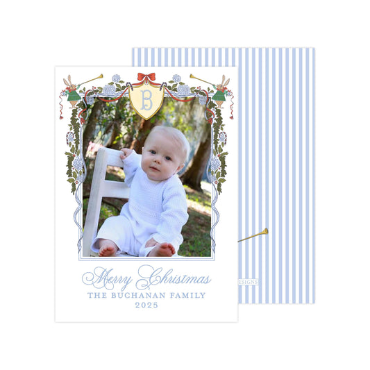 A baby sitting on a chair in a garden, surrounded by a decorative border with a monogrammed letter 'B' and festive holiday elements.