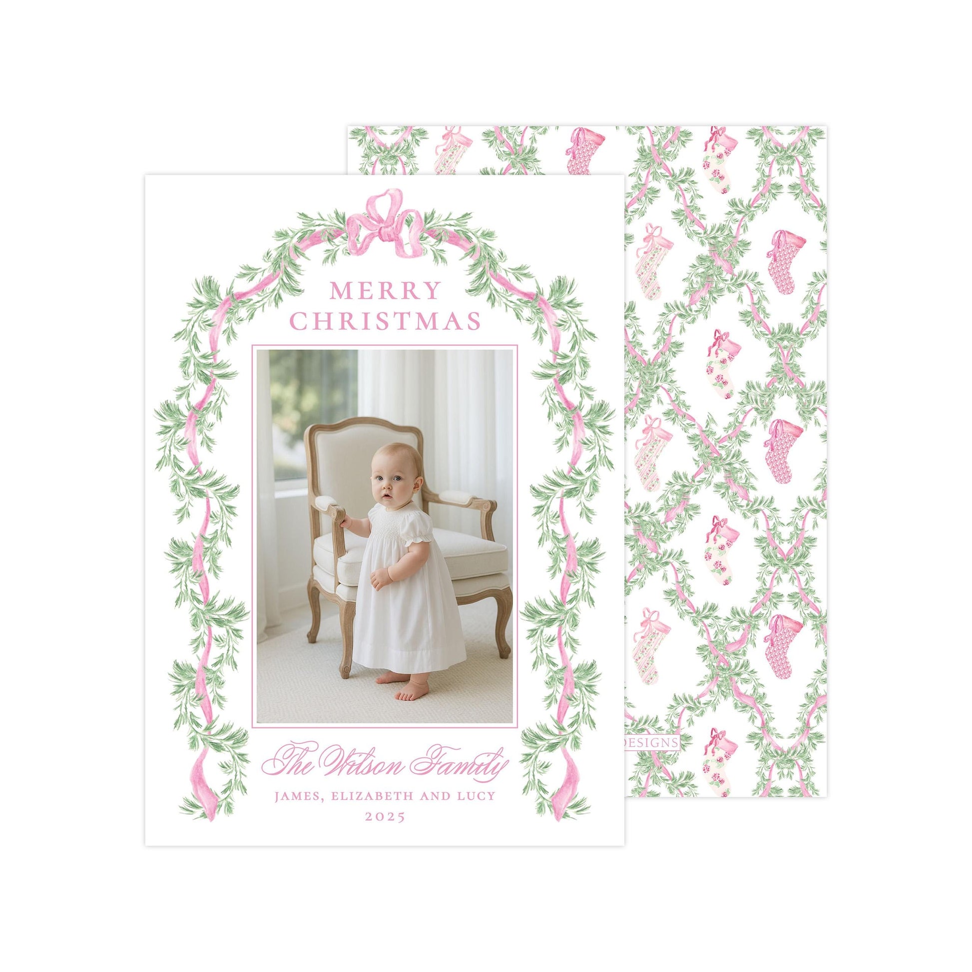 The image is a Christmas card featuring a baby girl in a white dress, standing in front of a chair with a floral border. The card has a pink and green color scheme and includes a photo of the baby girl.