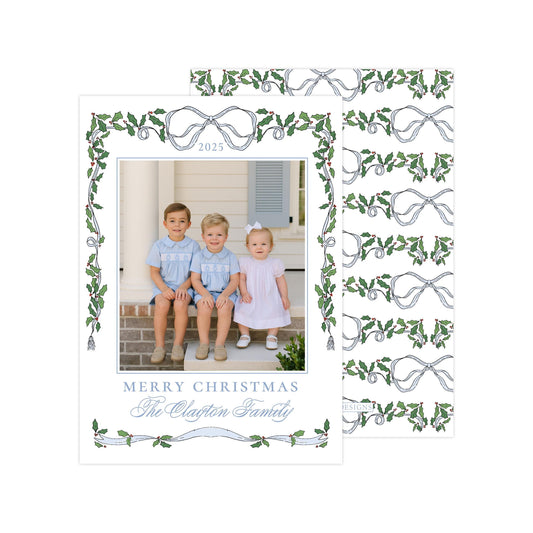 A family photo of three children sitting on a porch, with a decorative border and text that reads "Merry Christmas The Clayton Family".