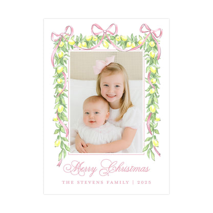 A young girl and a baby are sitting together in a frame, surrounded by a decorative border of lemons and pink ribbons. The text &quot;Merry Christmas&quot; is written in a cursive font at the bottom of the image.