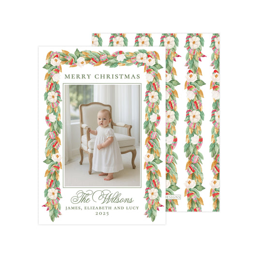 A holiday card featuring a baby girl in a white dress, with a floral border and text that reads &quot;Merry Christmas The Wilson&#39;s James, Elizabeth and Lucy 2015&quot;.