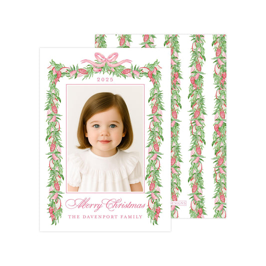 A young girl with brown hair is smiling at the camera, framed by a decorative border of green leaves and pink ribbons. The text on the card reads "Merry Christmas" and "The Davenport Family".