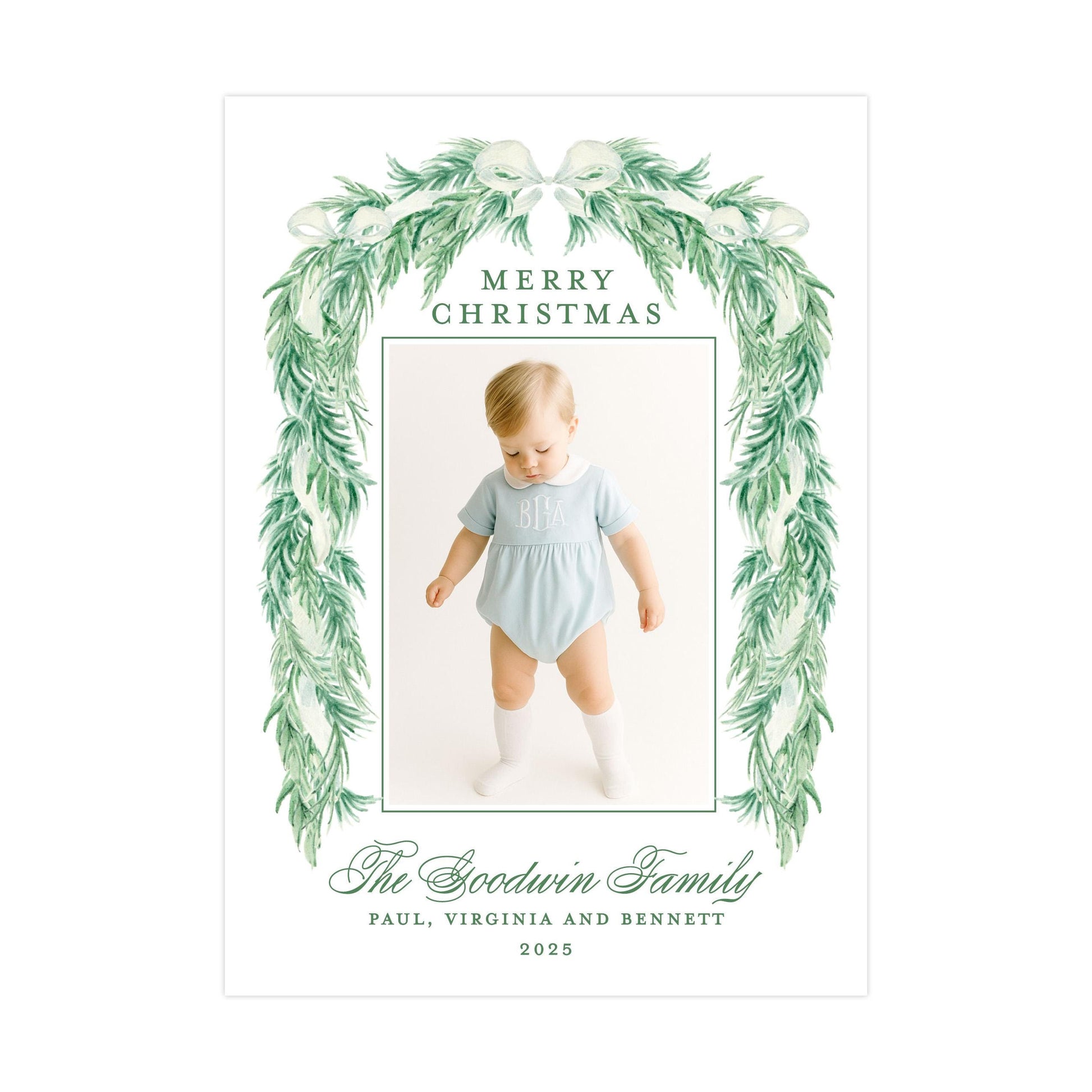 The image is a Christmas card featuring a baby wearing a light blue outfit, surrounded by a green wreath. The card has a message that reads "Merry Christmas" and includes the names "Paul, Virginia and Bennett" along with the year "2025".