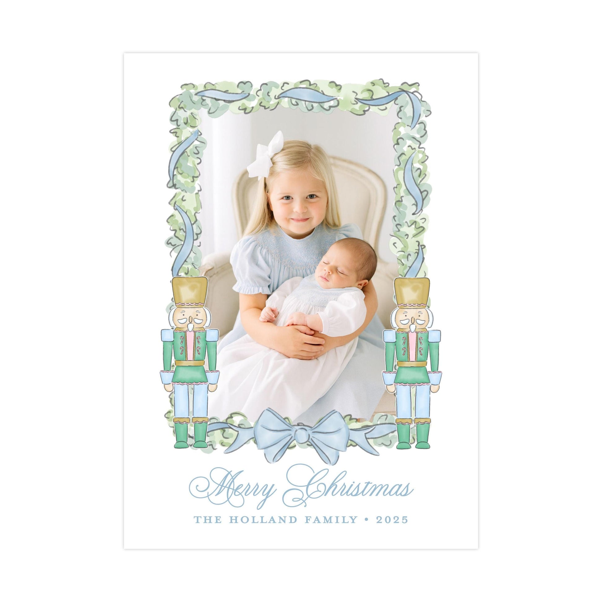A young girl is holding a baby in her arms, with a nutcracker figure on either side of the frame. The image is framed with a decorative border and the text &quot;Merry Christmas&quot; and &quot;The Holland Family&quot; is displayed below.