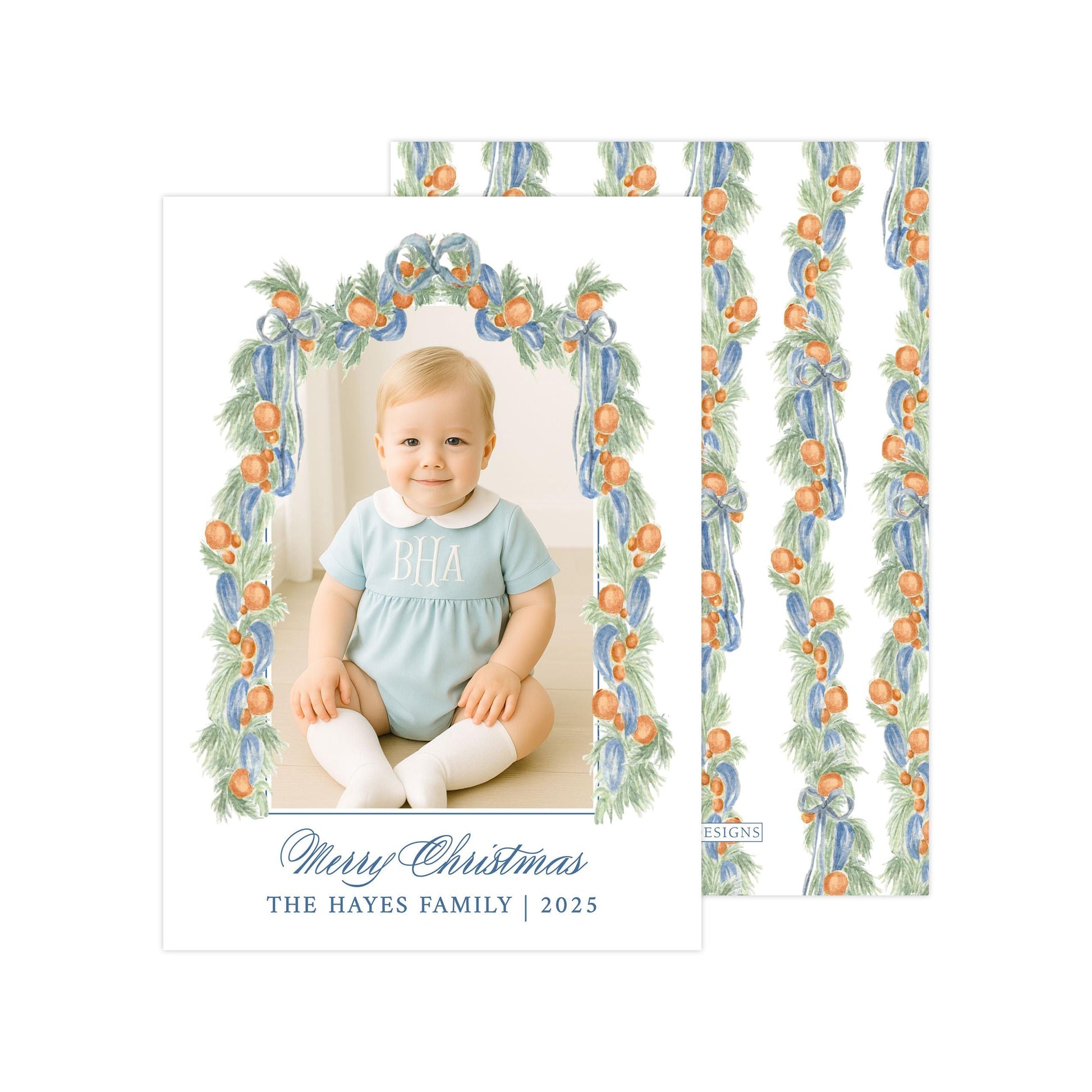 A photo of a smiling baby girl wearing a blue outfit, sitting in a frame with a floral border. The text below the photo reads "Merry Christmas THE HAYES FAMILY | 2025".