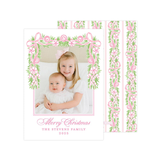 A young girl is holding a baby in a white dress, both smiling and posing for a photograph. The image is framed by a decorative border with pink and green floral elements. The text at the bottom of the image reads &quot;A merry Christmas THE STEVENS FAMILY 2015&quot;.