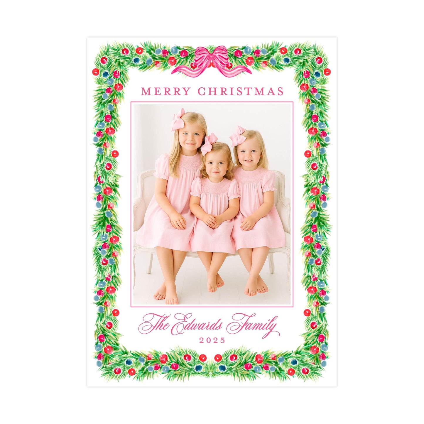 A family photo of three young girls in pink dresses, with a festive Christmas wreath border surrounding the image.